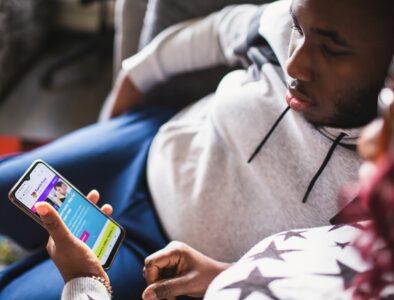 a teenager and his mum looking at the family fund website on a smartphone