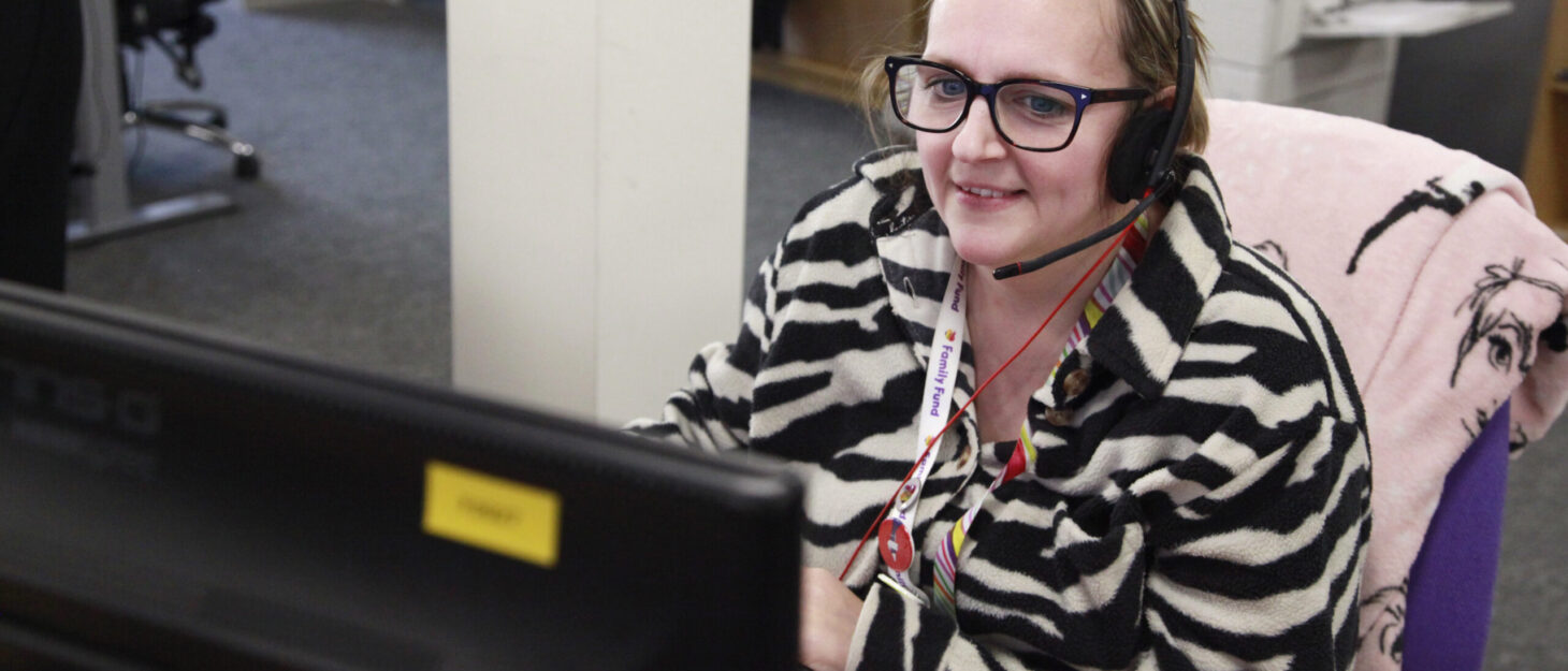 Family Fund colleague in office answers a call wearing her headset