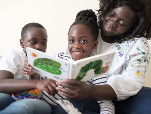 A family sat together reading a book with a caterpillar on the cover