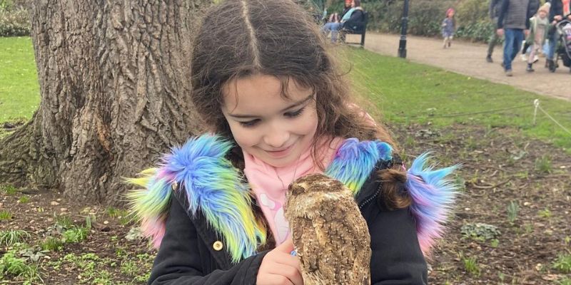 A girl with long hair holding an owl