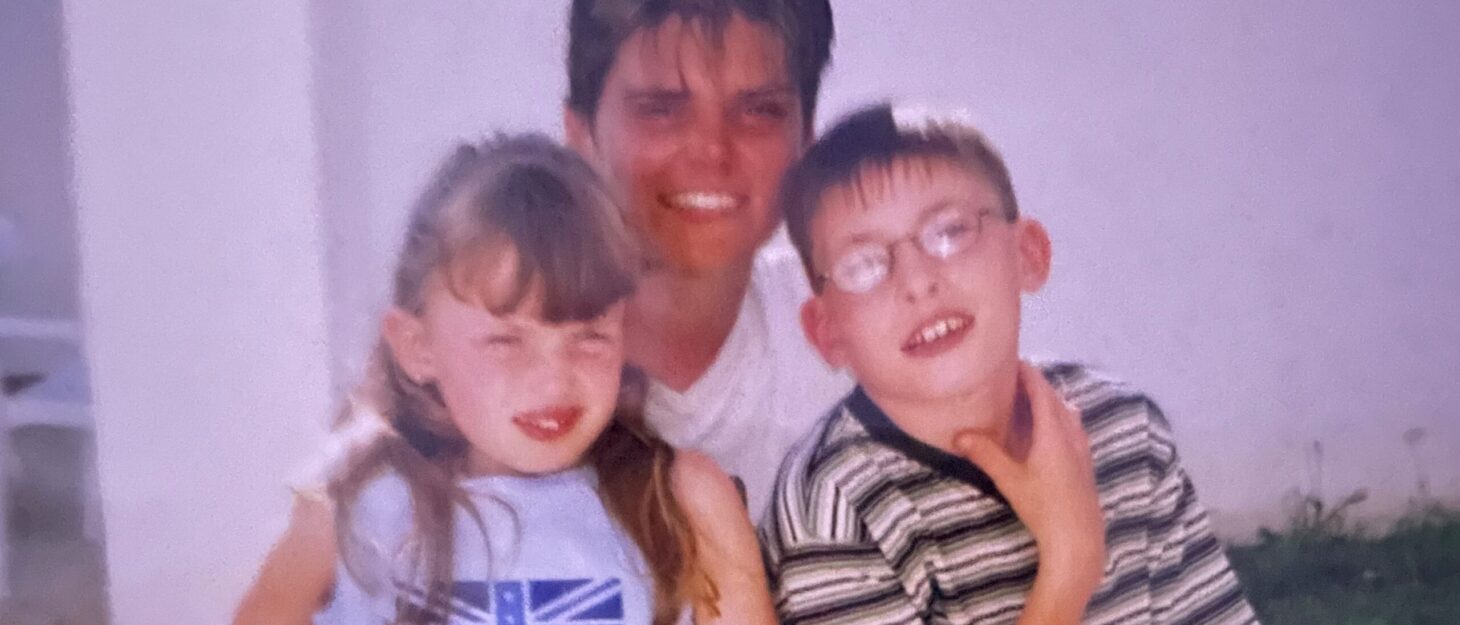 An old slightly blurry photo of a woman between her two young children