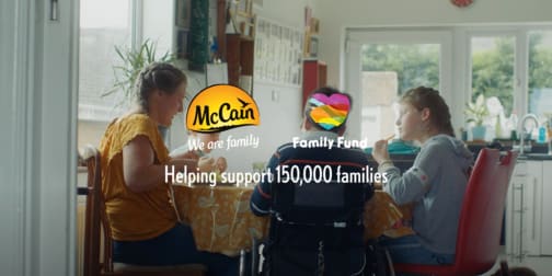 Family eating at a table with McCain and Family Fund logos