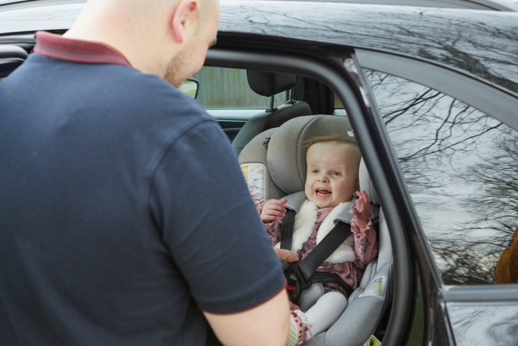 Baby in car seat looks happy and excited