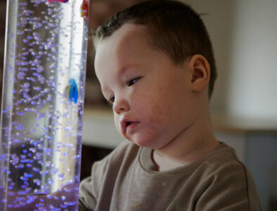A child looking at a sensory bubble toy.