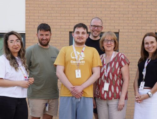 A group of colleagues stand outside the Family Fund offices.