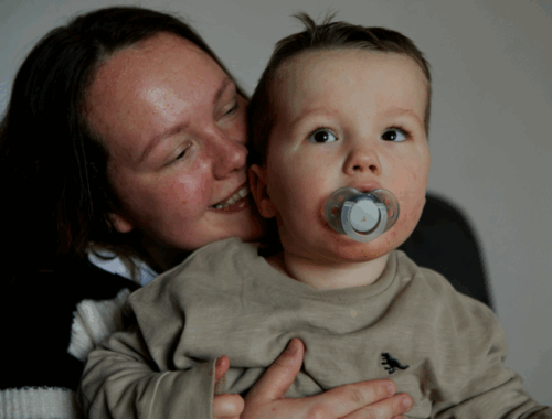 A woman hugging her little boy and smiling.
