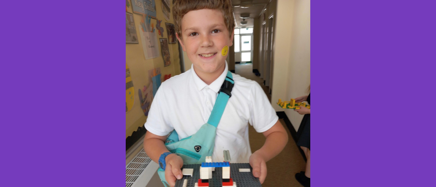 Noah standing holding lego.