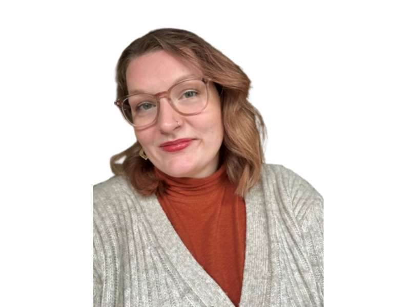 A woman wearing glasses smiles at the camera