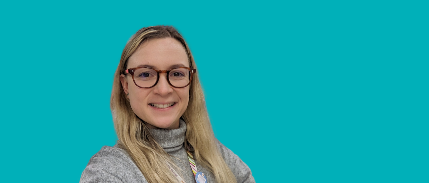 A close up of Angelika, Communications and Marketing Apprentice, against a blue background to mark National Apprenticeships Week 2025