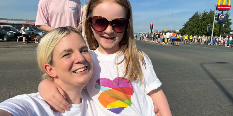 Laura and Daisy have their arms around one another, pictured at the Great North Run, wearing their Family Fund t-shirts. They are both smiling and Daisy is wearing sunglasses.