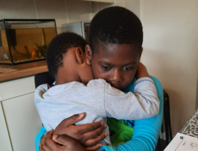 Two brothers give each other a hug.