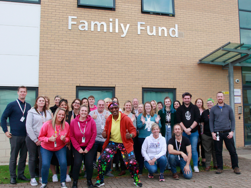family fund staff in front of the family fund building with Mr Motivator in the middle of the group