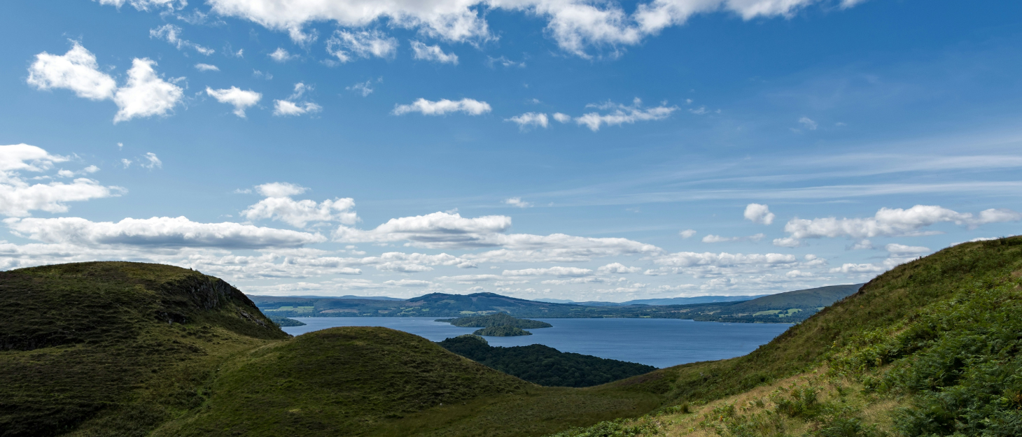 Scottish loch and highlands with blue sky and clouds