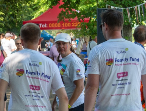 Three colleagues walking outside, with their backs to the camera, wearing Family Fund T-shirts
