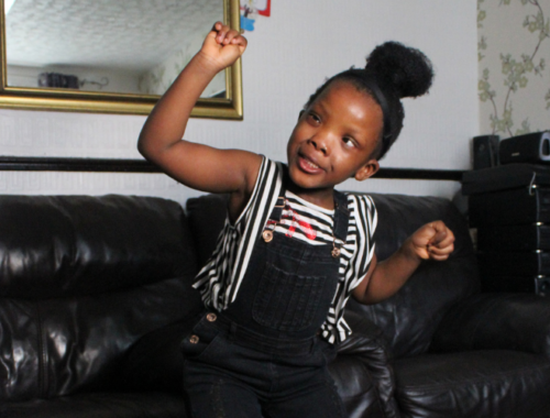 Girl dancing and smiling in her living room