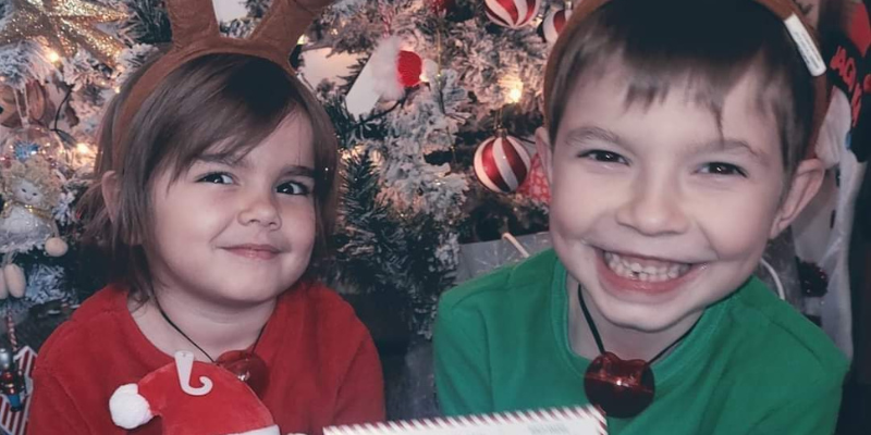 Hazel and Jago are pictured with the Christmas tree behind them and they are smiling