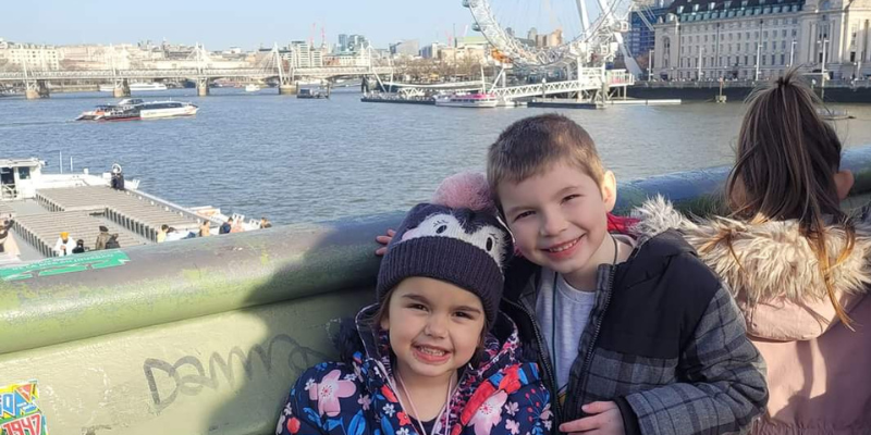 Hazel and Jago are both smiling next to one another, with the London eye behind them.