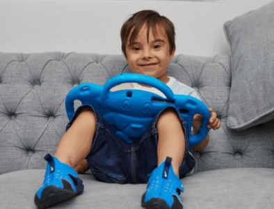 A young boy sitting on a sofa with a tablet.