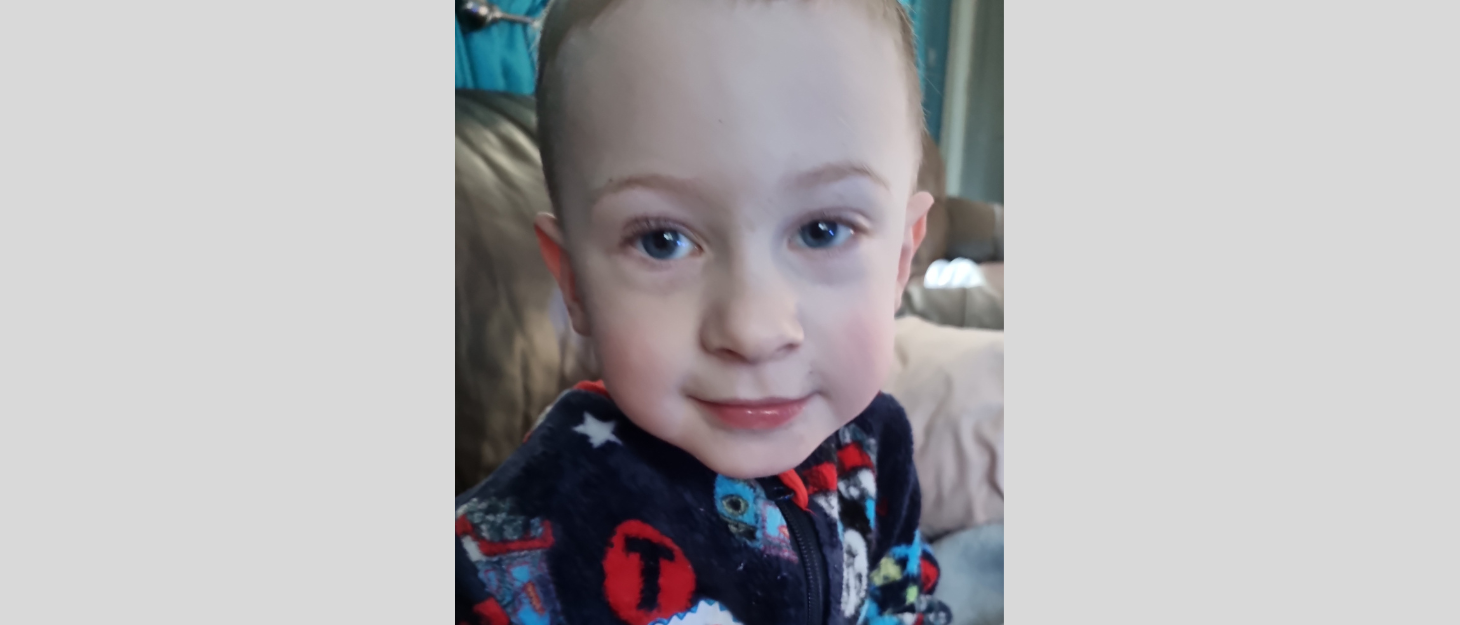 Young boy wearing pyjamas looks at camera