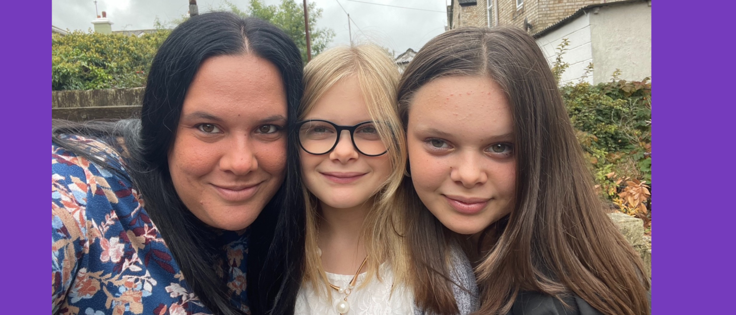 Sam, Molly and Lucy are all looking at the camera and smiling. Sam is taking the photo, and all of their faces are pressed to one another. They are outdoors.