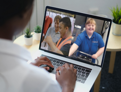 a woman looking at a laptop screen with photos of young disabled adults in workplaces
