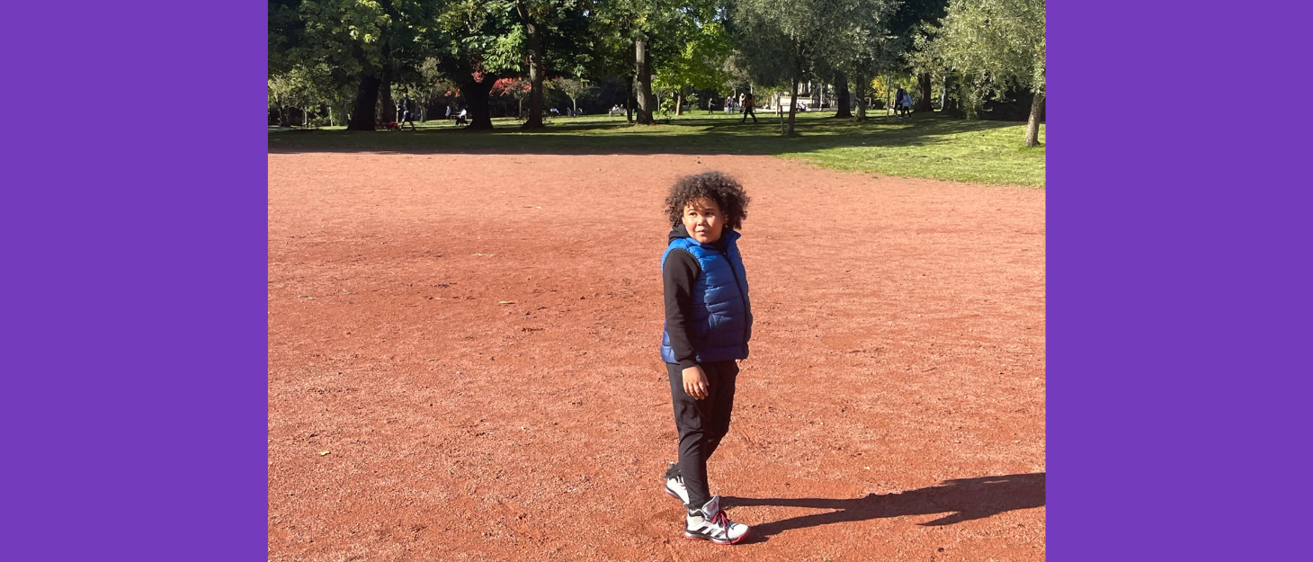 Boy in park looks back at camera