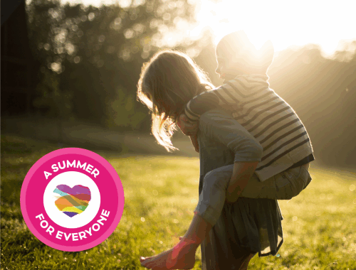 A young girl giving a young boy a piggyback outside in the sun.