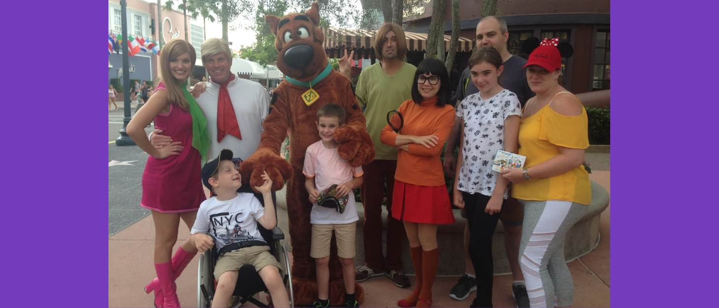 A family standing with a group dressed as the characters from Scoobie Doo on holiday