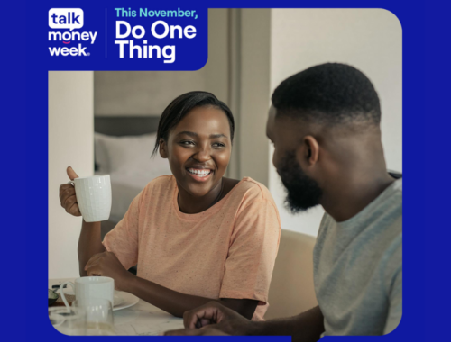 A man and a woman are sat at the table having hot drinks and smiling. Talk Money Week logo and text that reads: 'This November do one thing.'