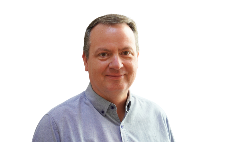 A man with short light brown hair, wearing a shirt and smiling