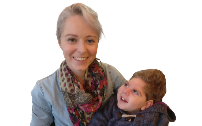 A lady with blonde hair pulled back, wearing a light denim jacket and red spotted scarf, she is holding her son